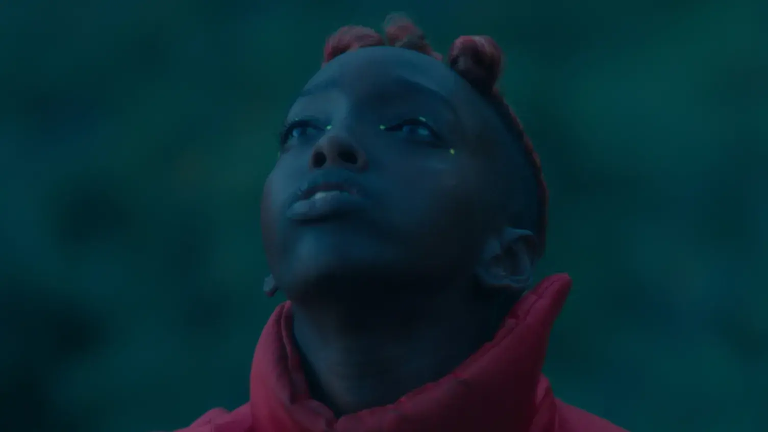 Young person looking up to the sky in a dark setting.