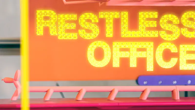 Yellow letters spell "Restless Office" on an orange background.