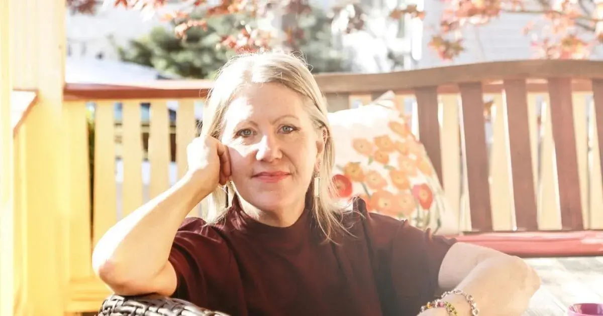 Headshot of Rebe Huntman, sitting outside in the sun