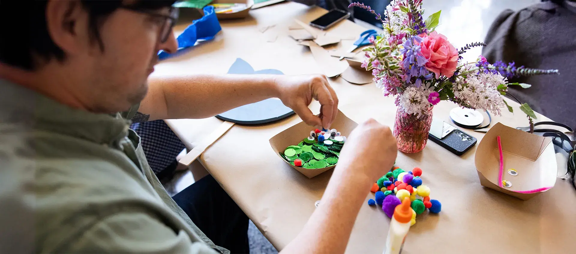 Bird's eye view of a person making art using colorful materials.