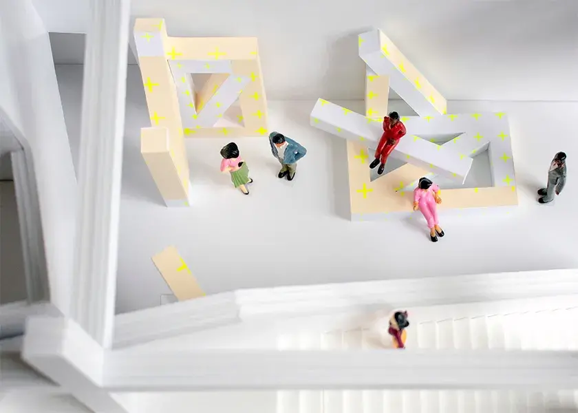 Overhead view of figurines in a mock-up of the Wexner Center’s lower level. They interact with geometrically shaped architectural elements.