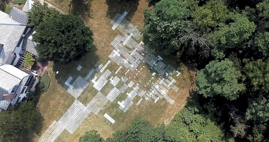 Overhead view of field with painted schematic design element of Ragdale campus in Illinois. People, trees, and buildings are visible.