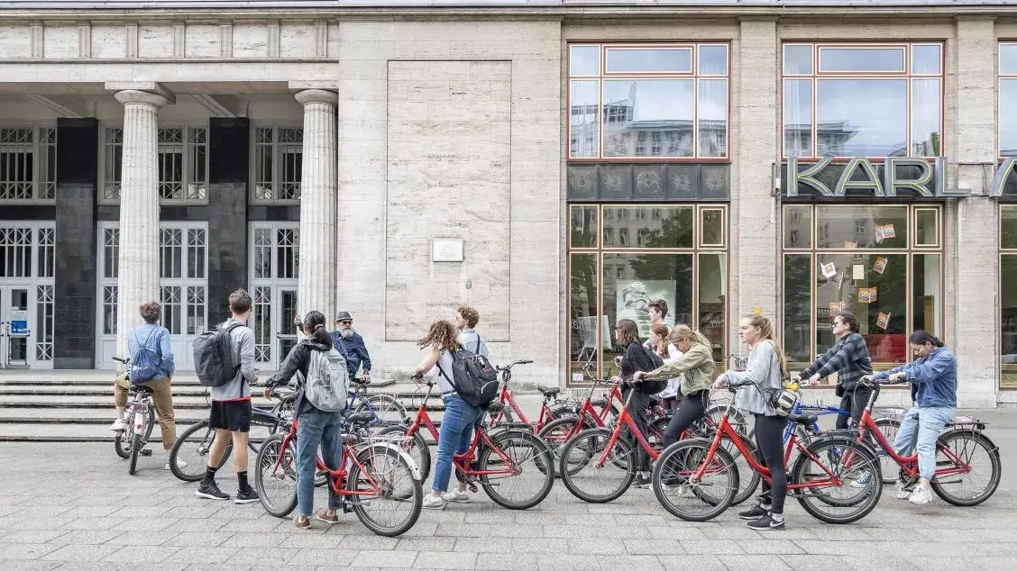 Students discuss mixed-used development and transportation infrastructure along the Karl-Marx-Allee during a biking tour of Berlin.