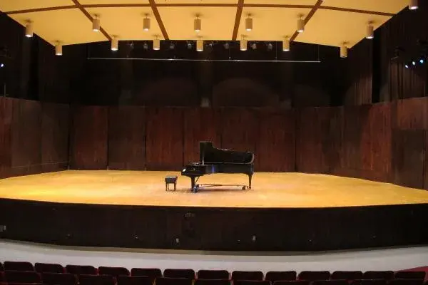 Black grand piano on a wooden stage