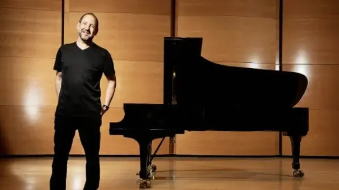 Man standing next to the piano. 