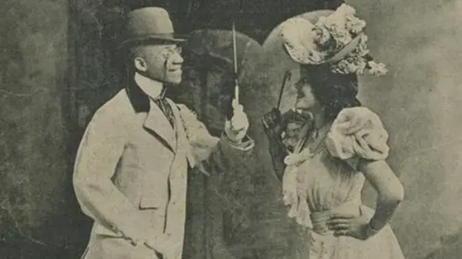 Grey and white image of Black man and White woman smiling at each other. 