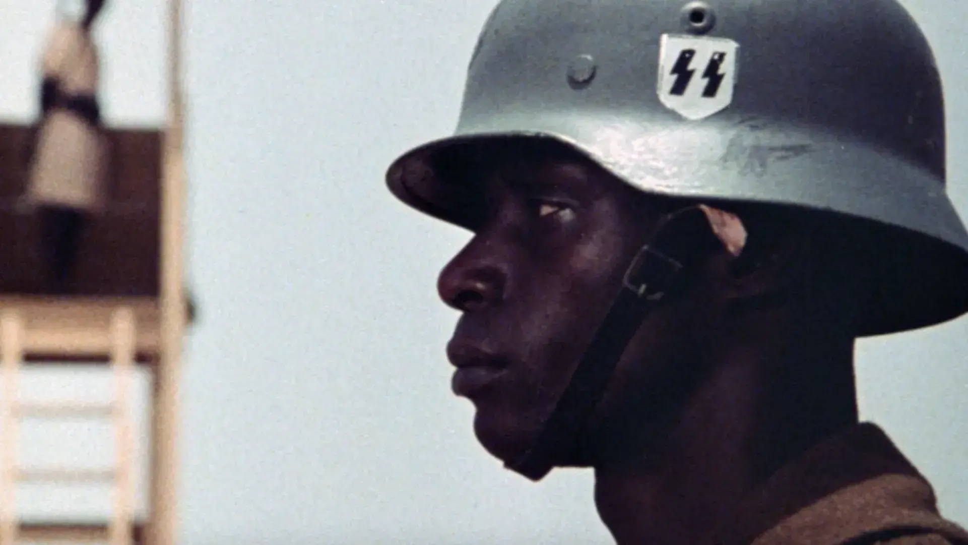 The profile of a Black man wearing a military helmet. 