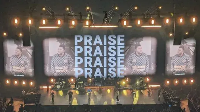 People standing infront of the screen saying "praise" a few times. 
