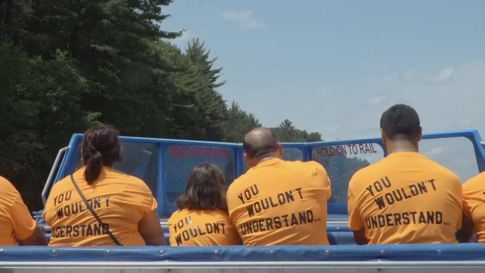 Six individuals in a boat facing away with shirts that say "you wouldn't understand"