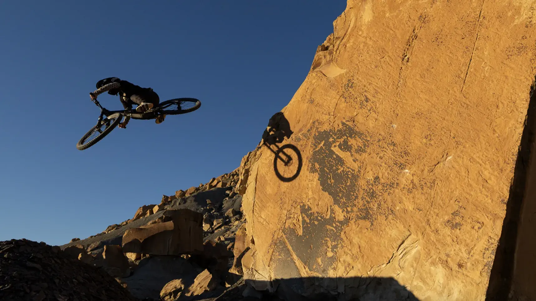 Guy up high doing tricks on his bike.
