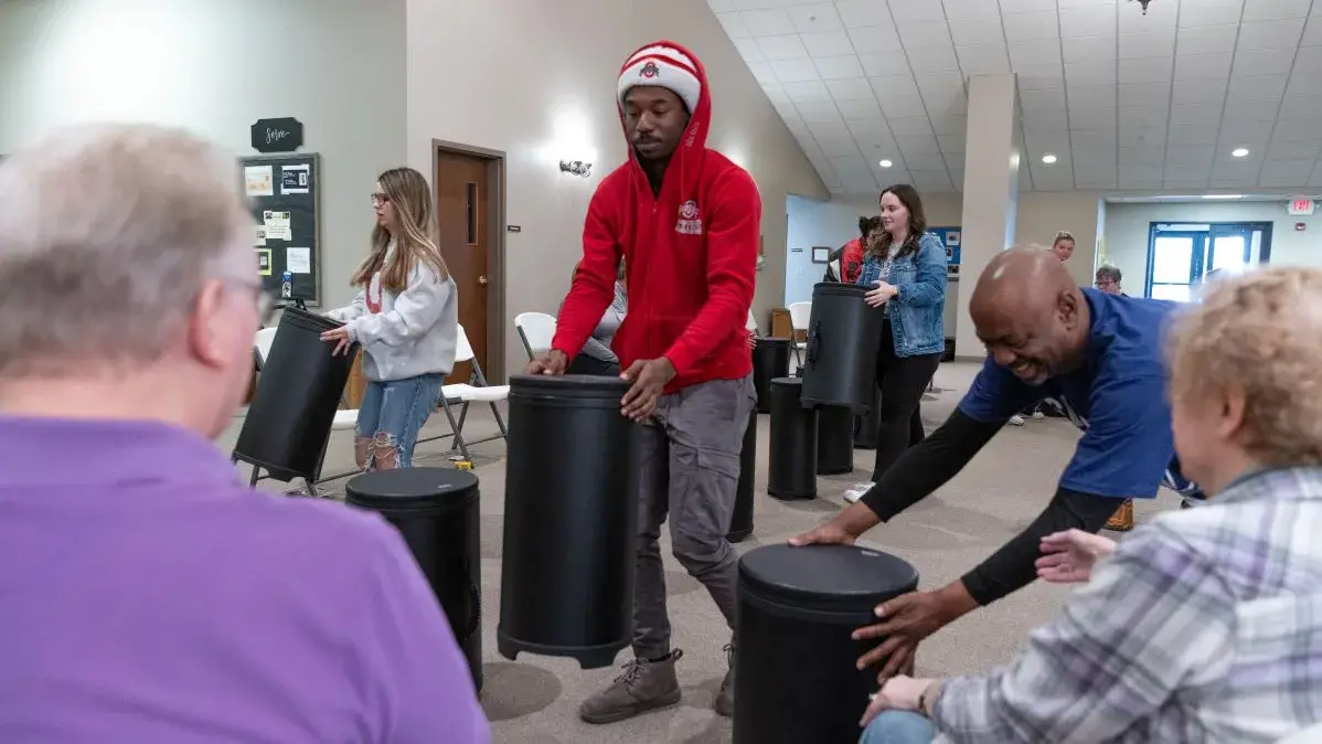People set up drums for people with Parkinson's