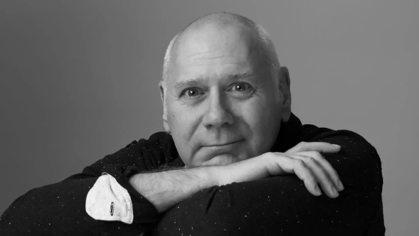 Doug Varone sits backwards on chair, facing the camera