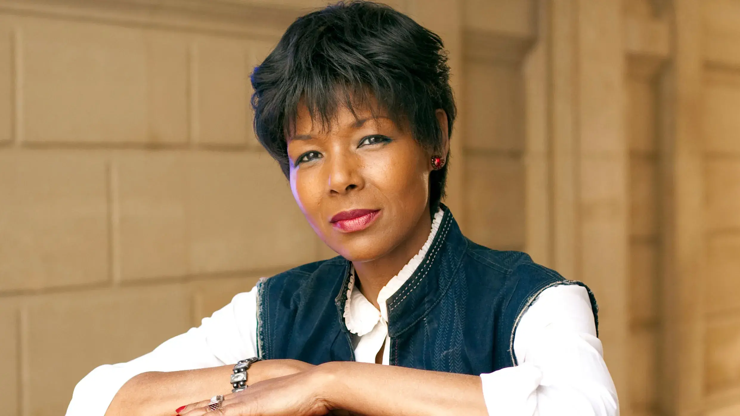 Euzhan Palcy looks at the camera. She has medium brown skin and short dark brown hair