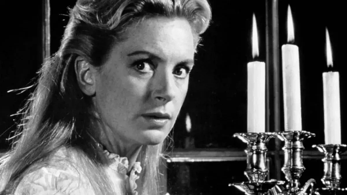 A black and white closeup of a woman holding a candelabra.