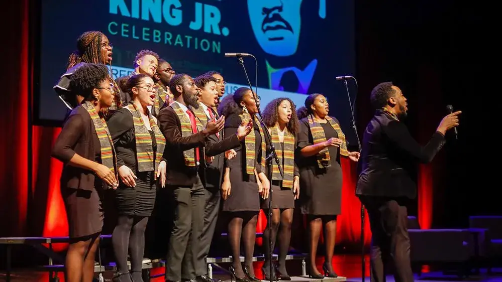 Several Black people stand on risers and sing