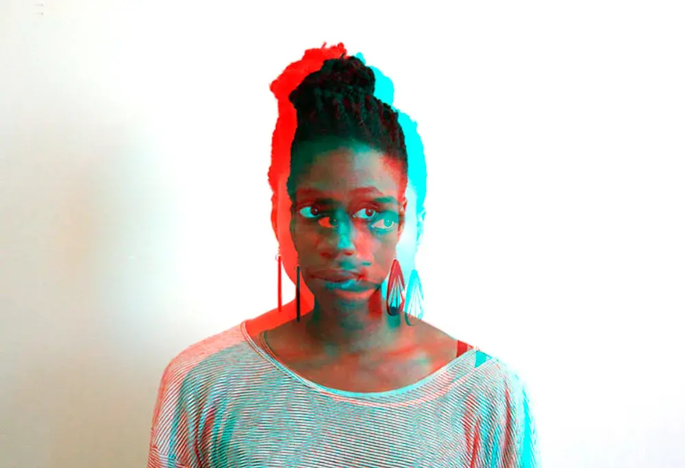A Black woman looks away from the camera and there are red and blue shadows on the manipulated image