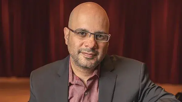 Dror Brian, a bald man with glasses, looks at the camera