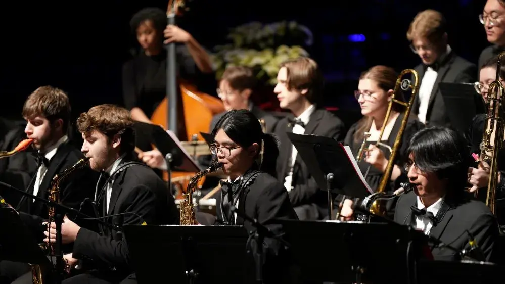 Young people playing musical instruments on a darkened stage