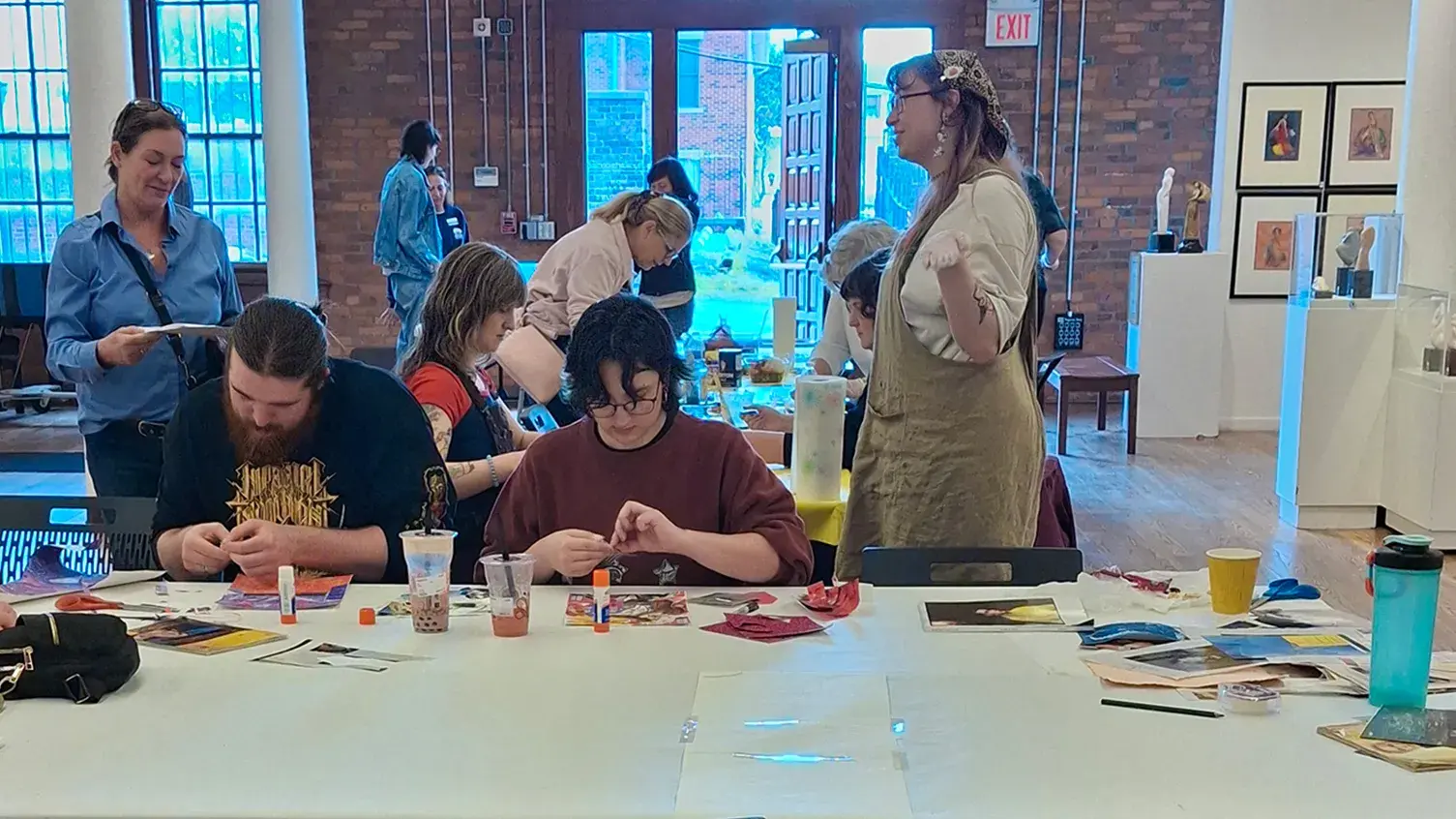 Several people sit at a table and make art