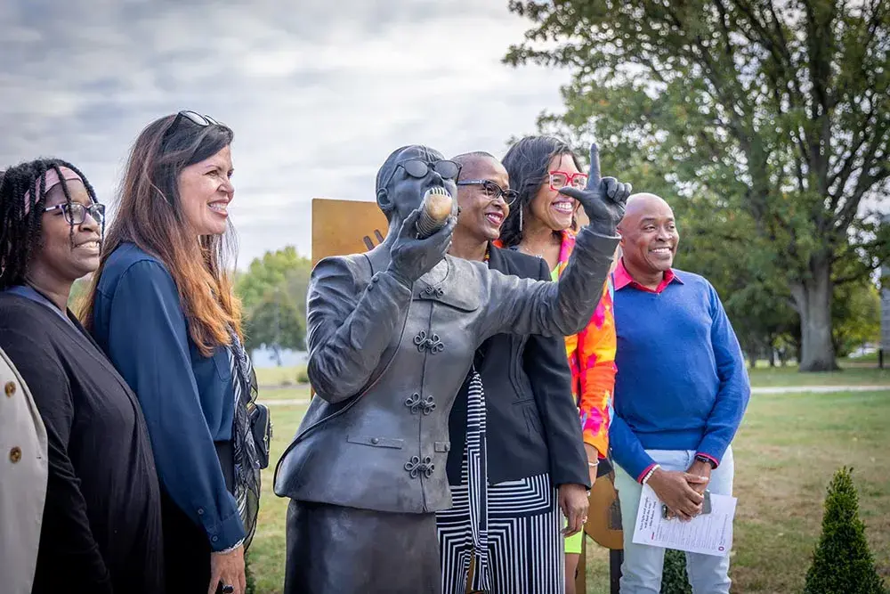 Several people pose with statue of Ella Baker