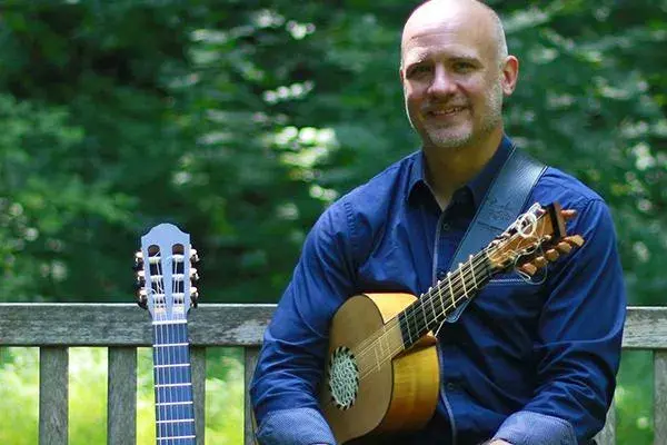 Karl Wohlwend holding a guitar.
