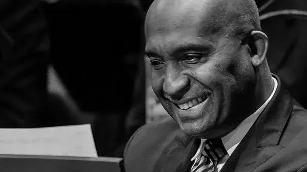 Black and white image of Bobby Floyd, a Black man wearing a tie and jacket and smiling