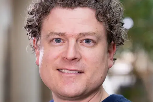 Headshot of Tim Chenette, a white man with curly brown hair