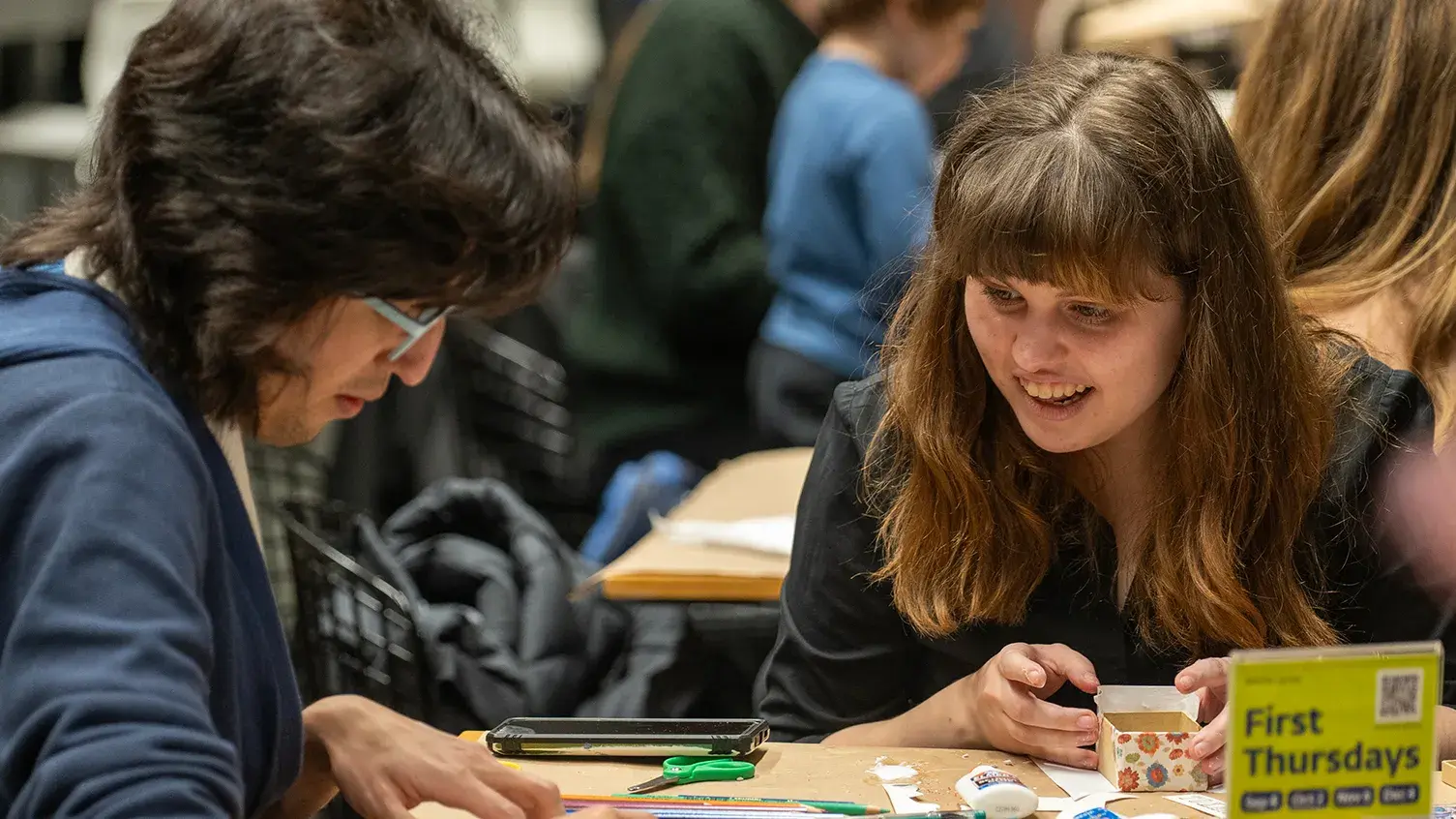 People sit at a table and make art