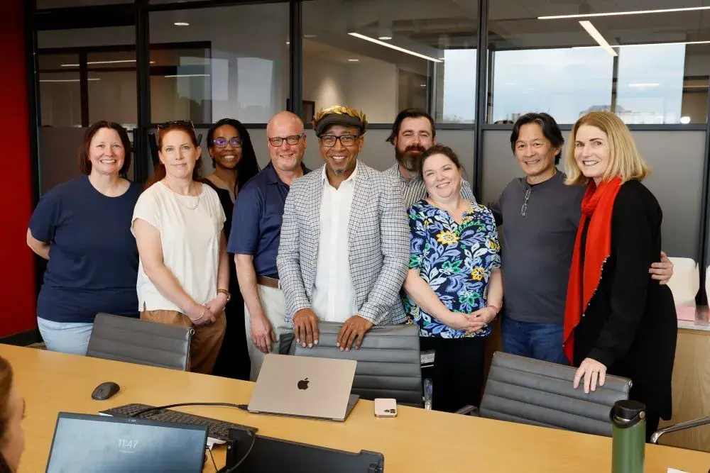 Charles O. Anderson wears a golden wreath on his head and is surrounded by several other adults