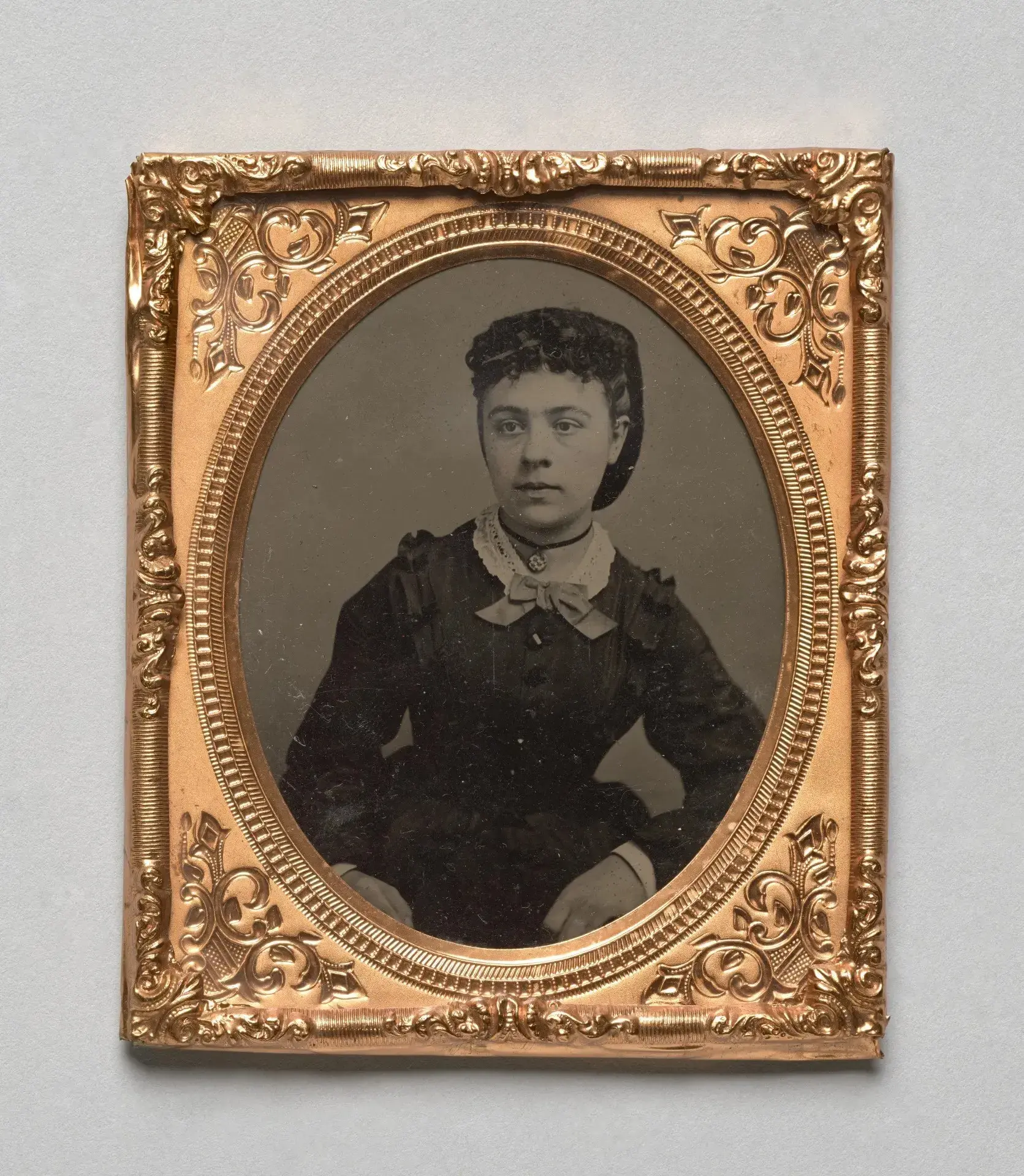 Vintage black and white photograph of a woman in an ornate gold frame