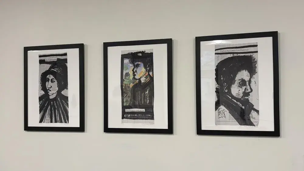 Three framed artworks on a wall