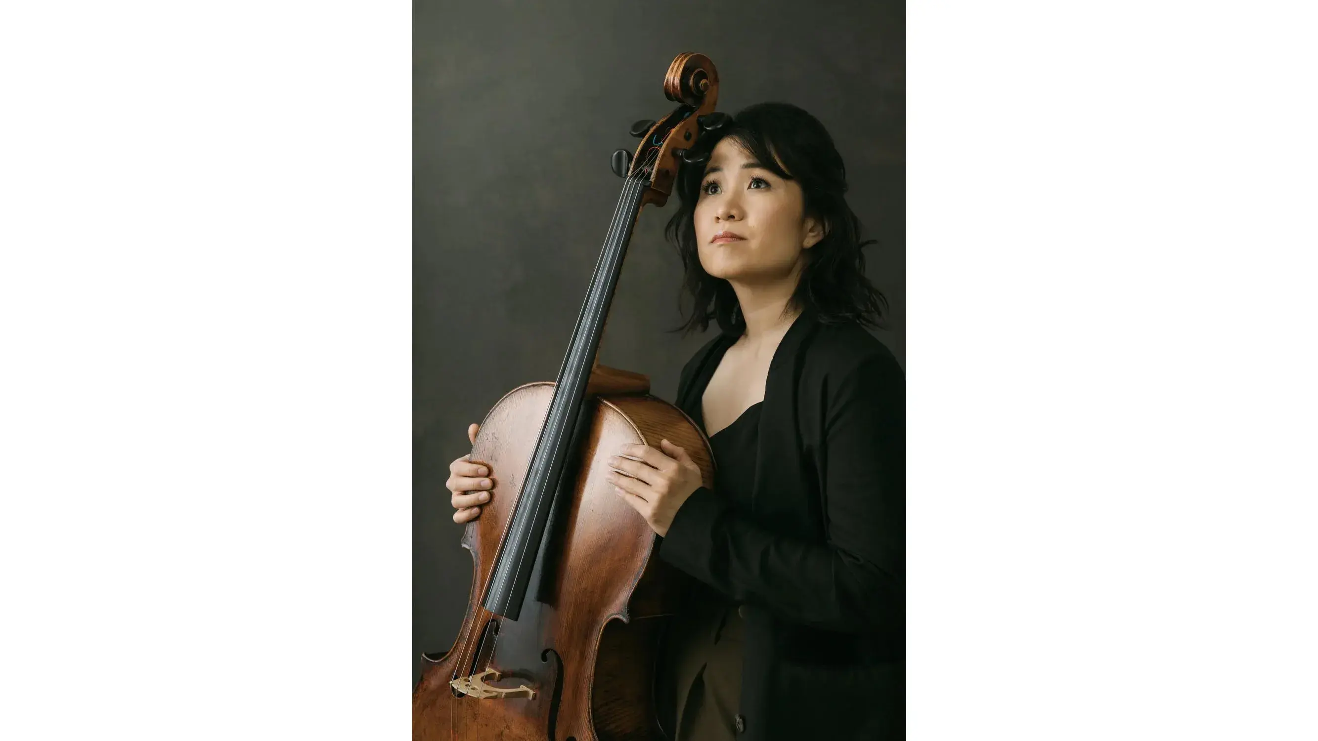 A headshot of Julia Yang, as Asian woman holding a cello