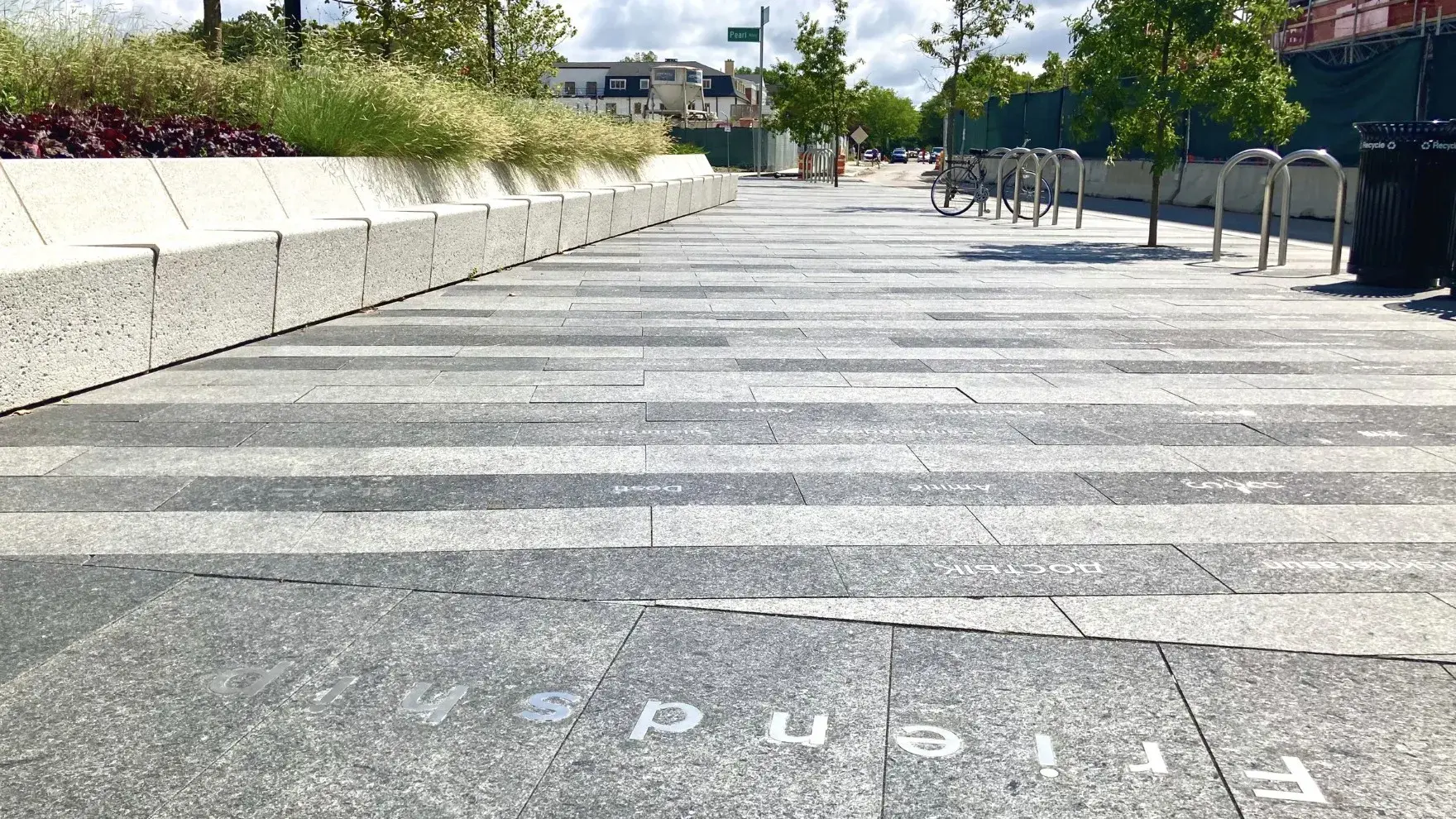 The word "Friendship" appears on a wide granite walkway with other languages visible beyond it.
