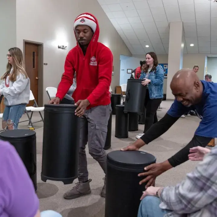 People set up drums for people with Parkinson's