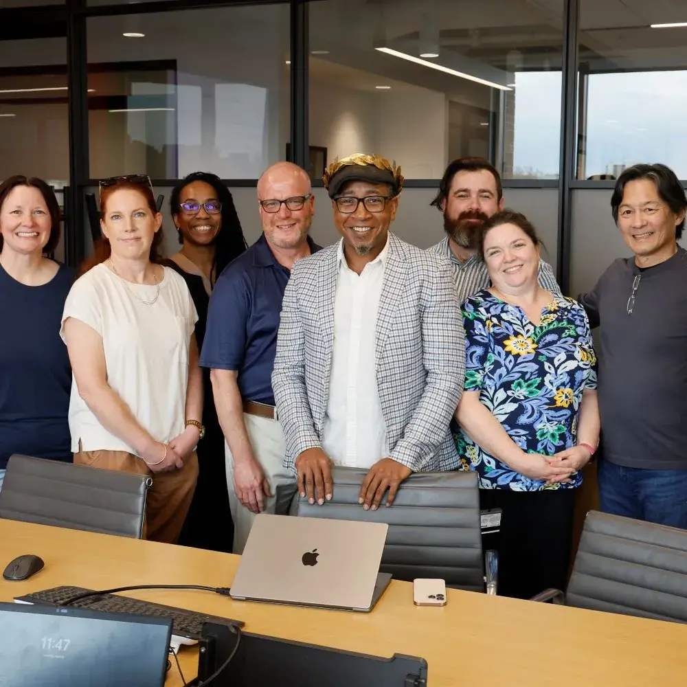 Charles O. Anderson wears a golden wreath on his head and is surrounded by several other adults