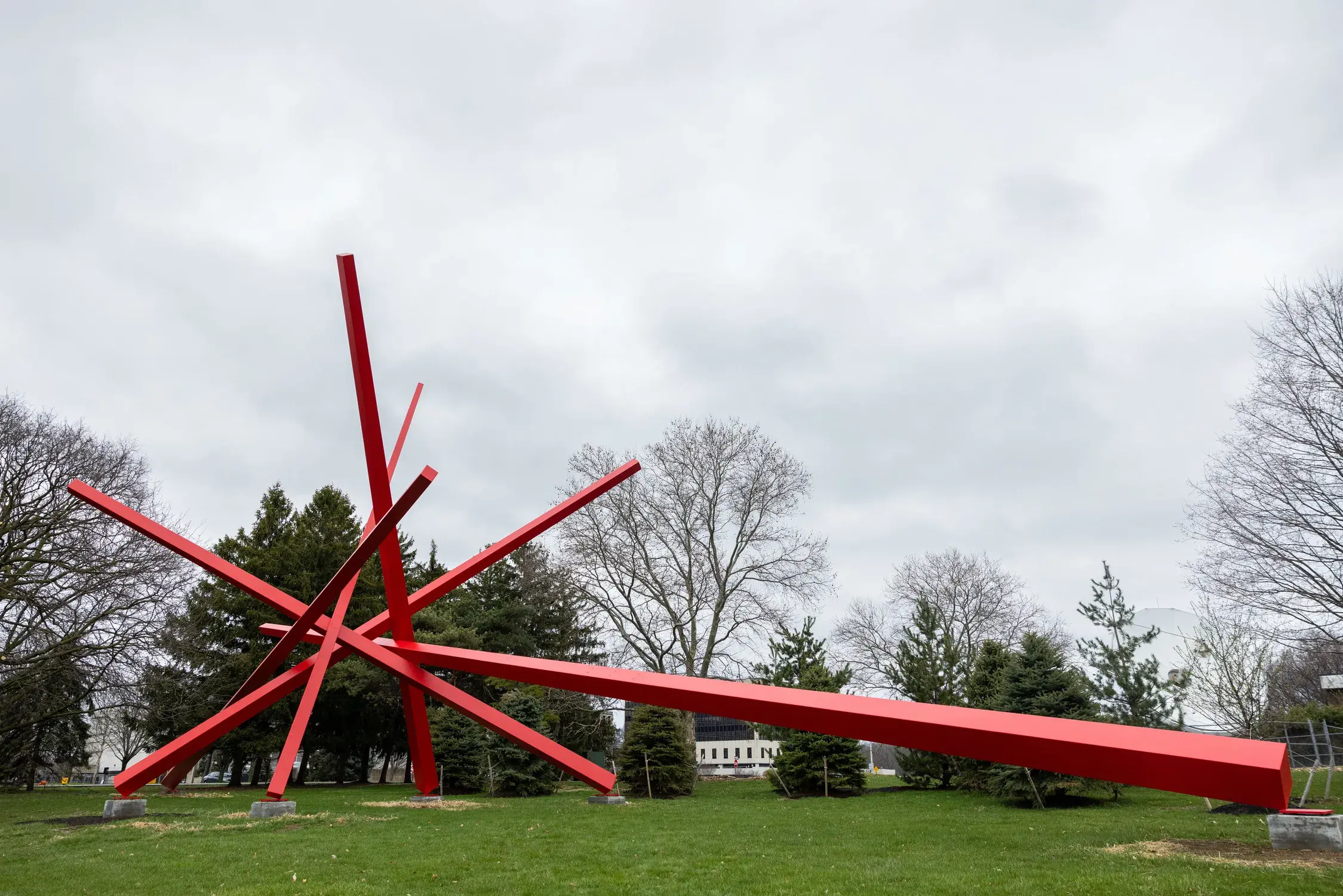 Outdoor sculpture of 5 intersecting red bars of varying lengths