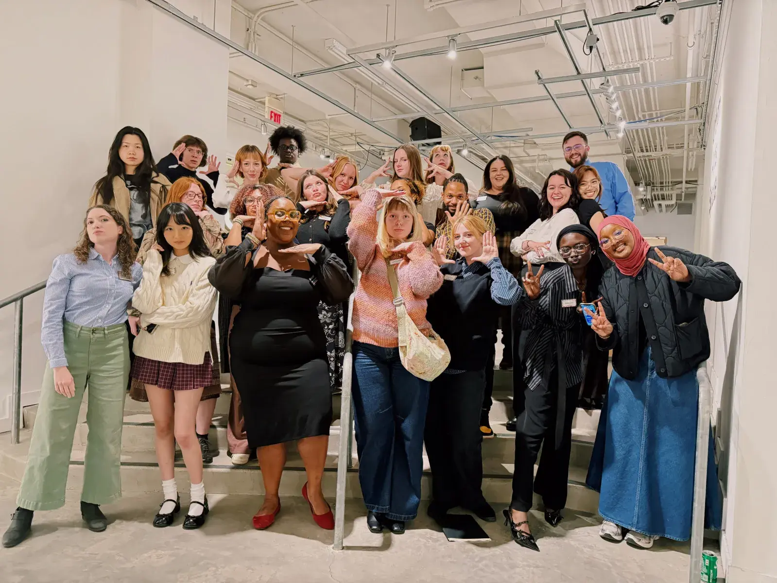 A group of young people stands together and mug for the camera