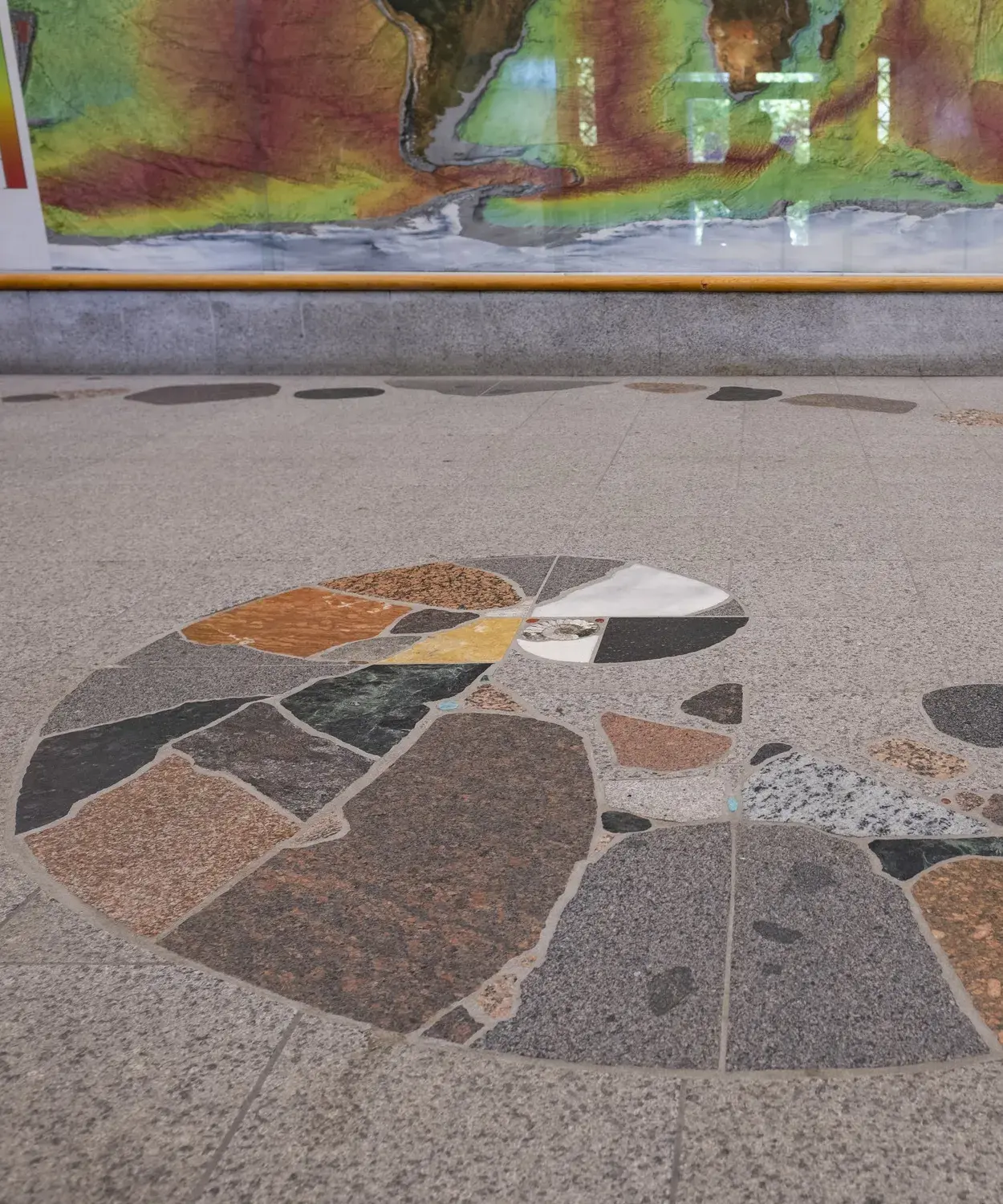 A floor design with a spiral shape made of different types and colors of rocks