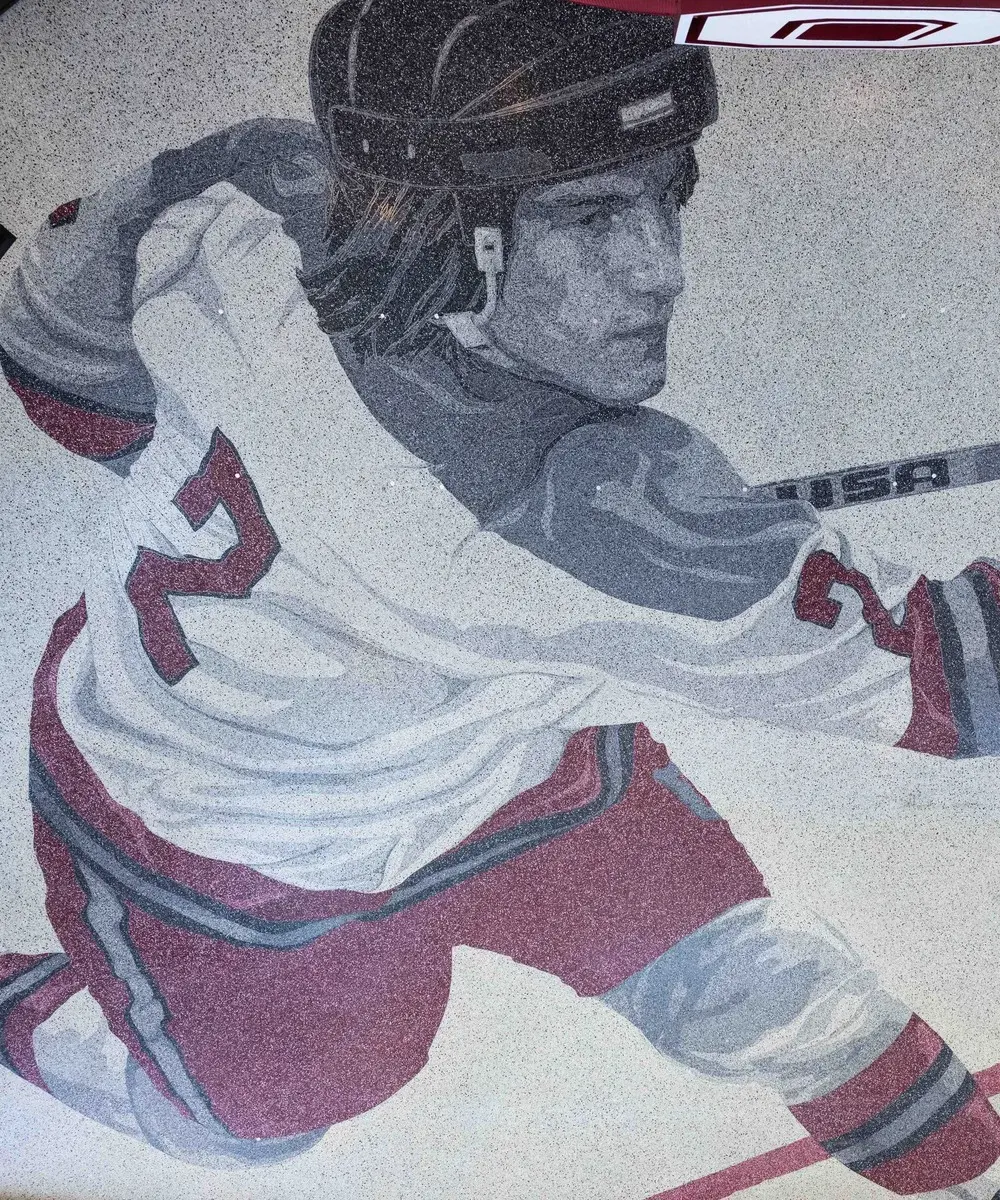 Floor design in grayscale and red shows a hockey player skating with their hockey stick and a number 2 on their back