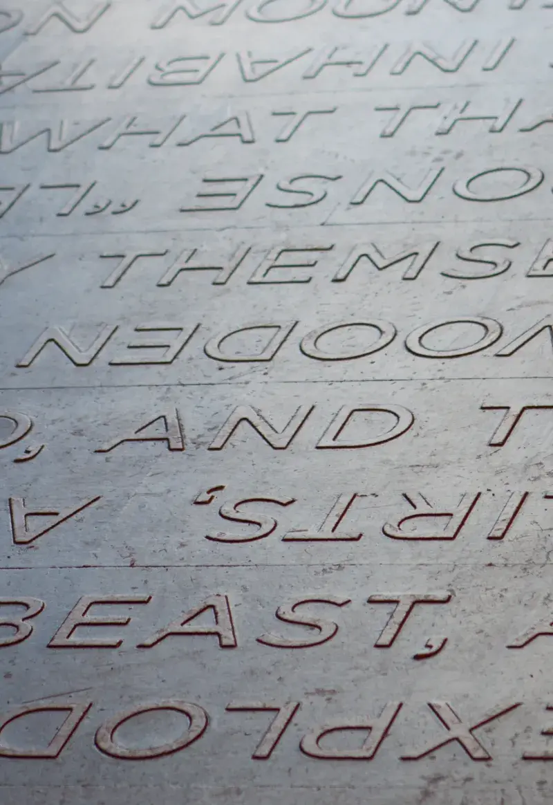 Light brown floor with lines of lighter brown words slightly raised up from the surface.