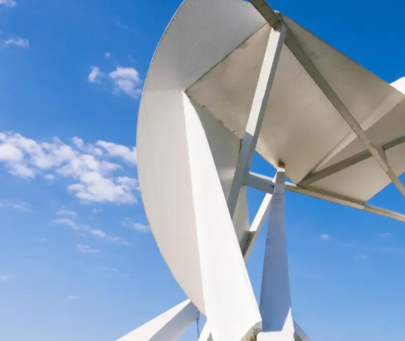 An abstract white sculpture in front of a bright blue sky