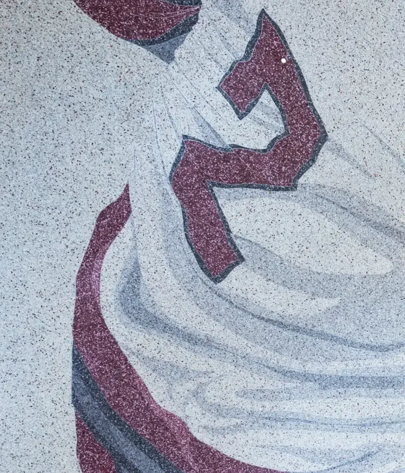 Close up of a floor design in grayscale and red shows a hockey player in action with a number 2 on their back